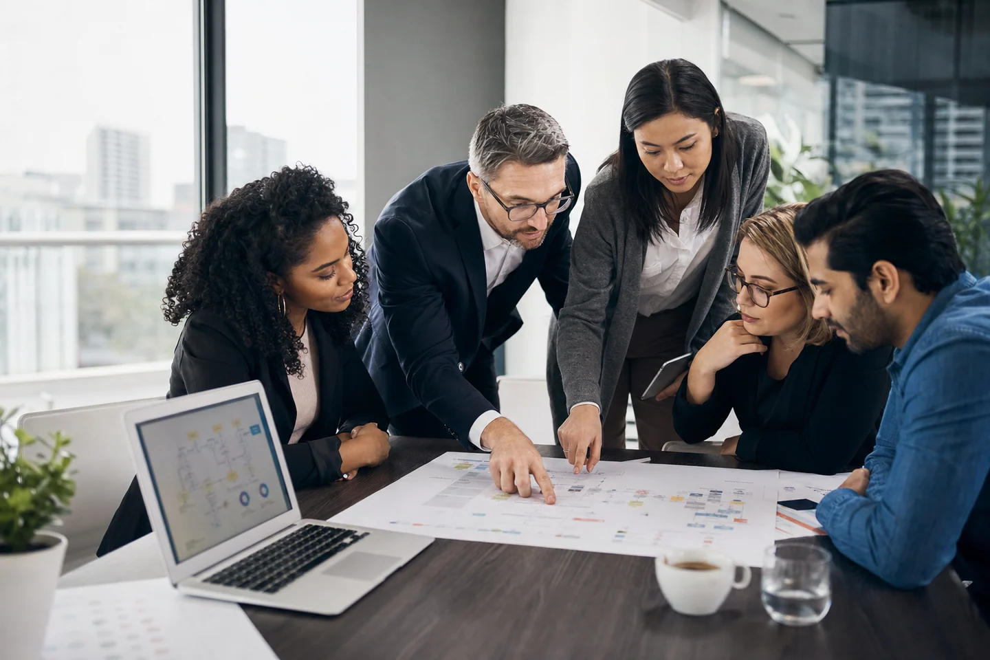 Business consultants reviewing AI automation workflows, dashboards, and client process maps in a modern office.